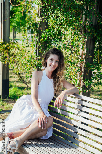 Beautiful woman in white summer dress walking in park