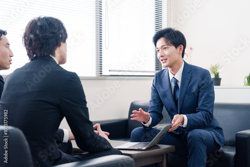 得意先と商談をするスーツを着たビジネスマン