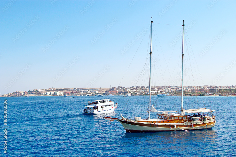 sailboat is sailing in the sea. People swim in sea during summer holidays sailboat is sailing in the sea. People swim in sea during summer holidays