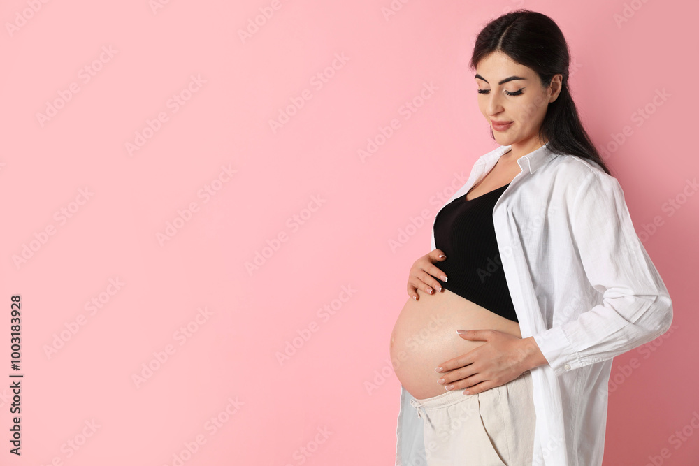 Portrait of beautiful pregnant woman on pink background, space for text Portrait of beautiful pregnant woman on pink background, space for text