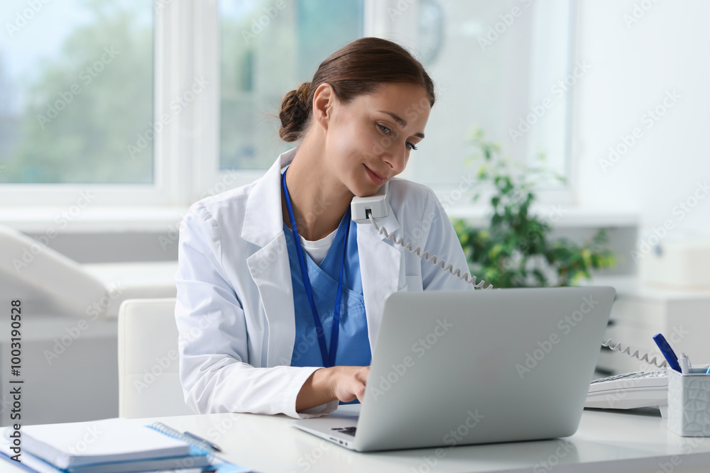 Nurse consulting patient by phone at white table in clinic Nurse consulting patient by phone at white table in clinic