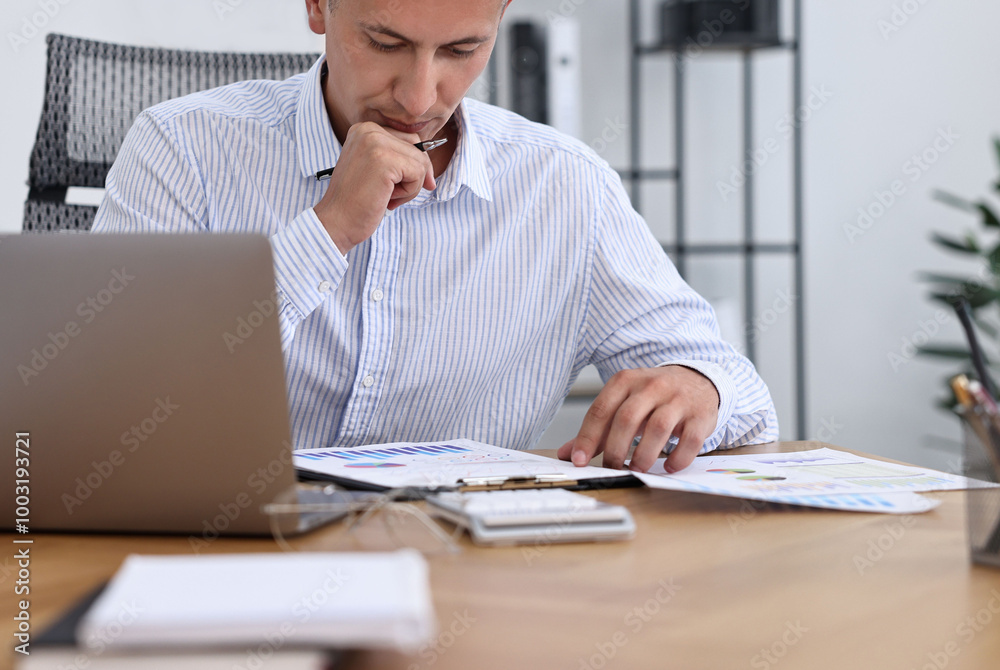 Banker working at wooden table in office Banker working at wooden table in office