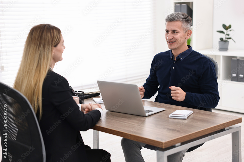 Banker working with client at table in office Banker working with client at table in office