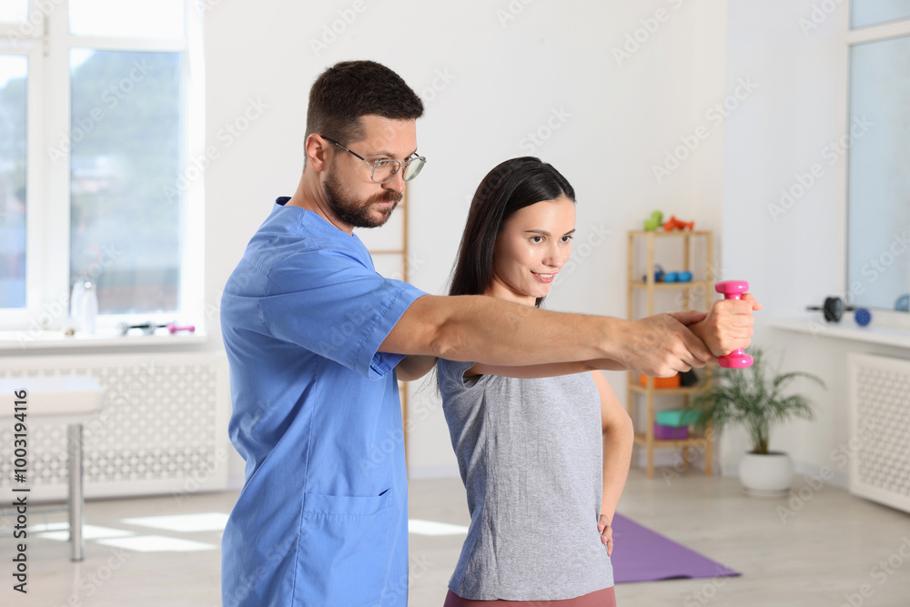Fototapeta premium Patient exercising under physiotherapist supervision in rehabilitation center