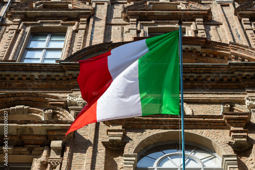 Italian flag waving above city buildings photo