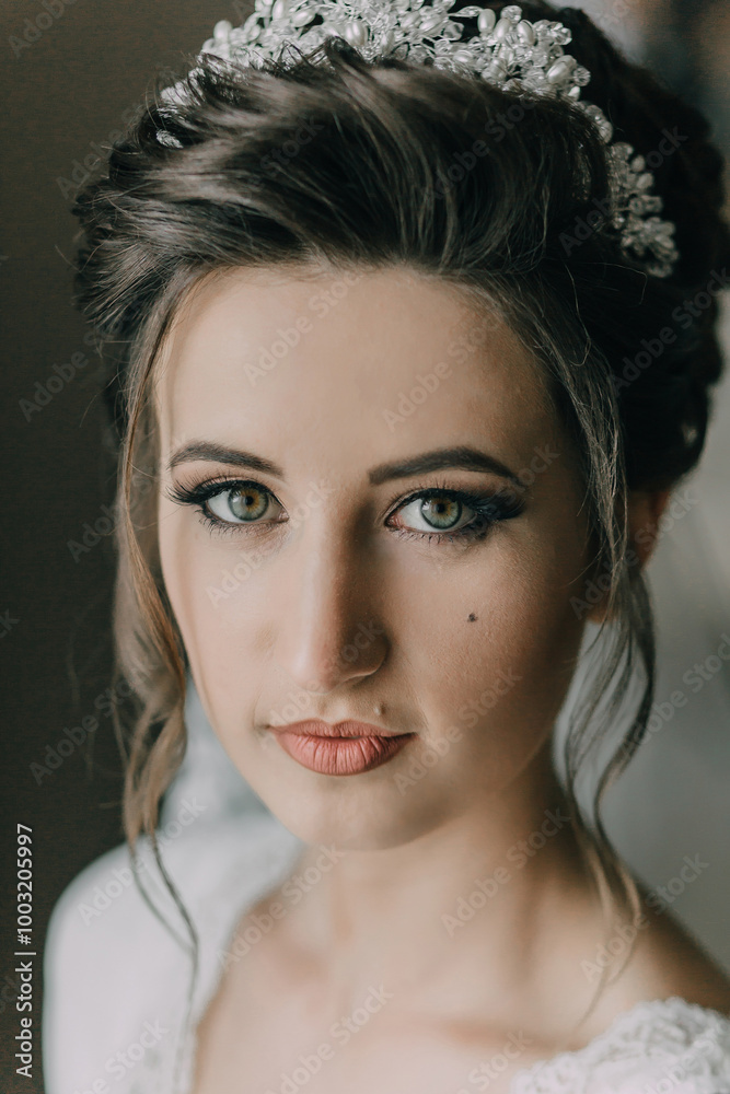 A woman with a tiara on her head. She has green eyes and is wearing red lipstick A woman with a tiara on her head. She has green eyes and is wearing red lipstick