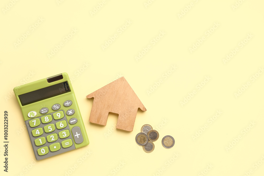Calculator, wooden house and coins on yellow background Calculator, wooden house and coins on yellow background