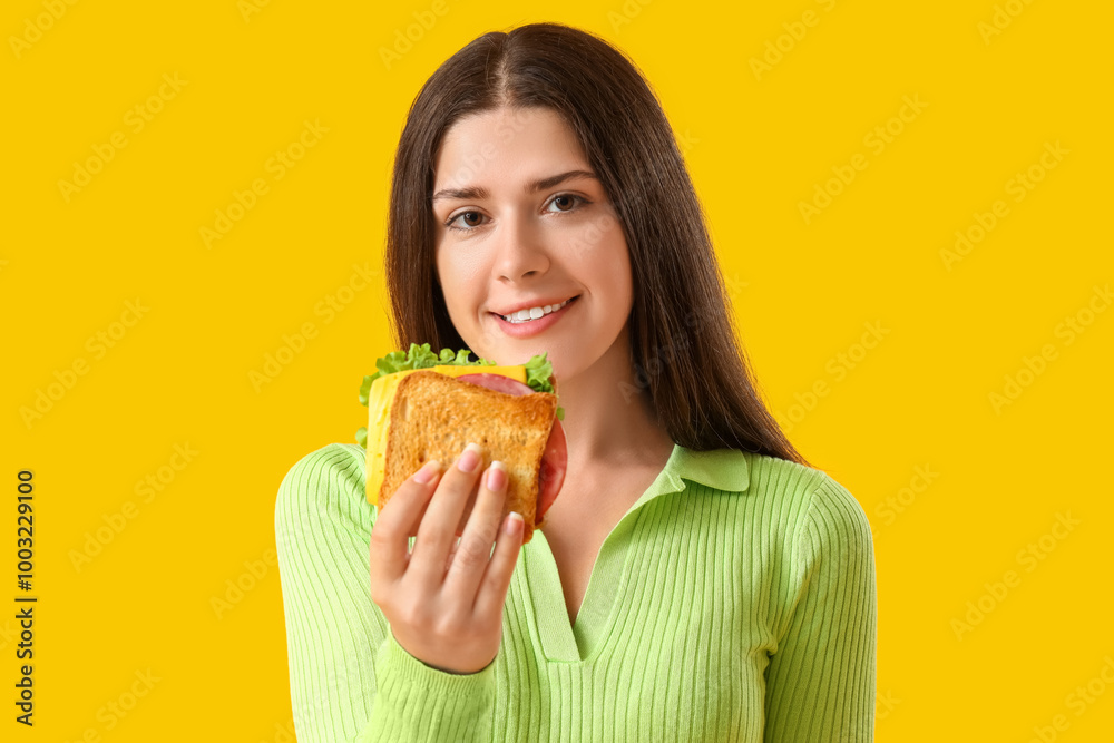 Young woman with tasty sandwich on yellow background, closeup Young woman with tasty sandwich on yellow background, closeup