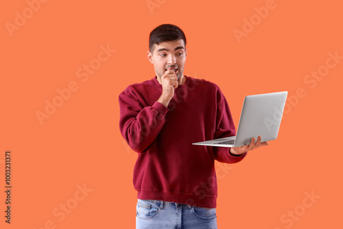 Afraid young man with lapto...