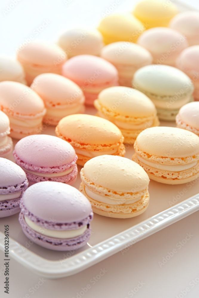 A tray of colorful pastel macarons beautifully arranged in neat rows, with flavors ranging from lavender to peach, creating a delightful and visually appealing presentation. A tray of colorful pastel macarons beautifully arranged in neat rows, with flavors ranging from lavender to peach, creating a delightful and visually appealing presentation.