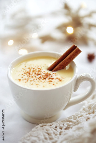 A cozy cup of creamy eggnog garnished with cinnamon sticks and sprinkled with nutmeg, perfect for the holiday season.