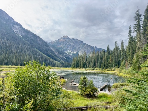 Lake in the mountains landscape water mountain nature forest sky reflection trees river snow tree view. Lake in the mountains clouds scenic pond travel summer park outdoors green rocky.