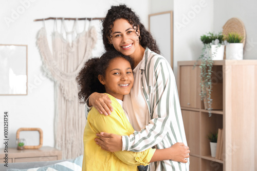 Happy young African-American woman with her daughter hugging at home