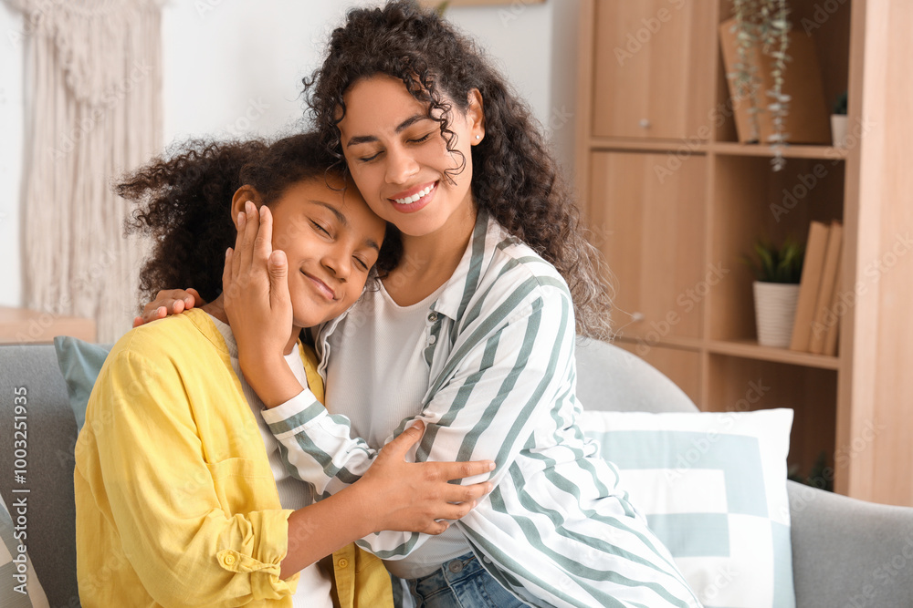 Obraz premium Young African-American woman with her daughter hugging at home