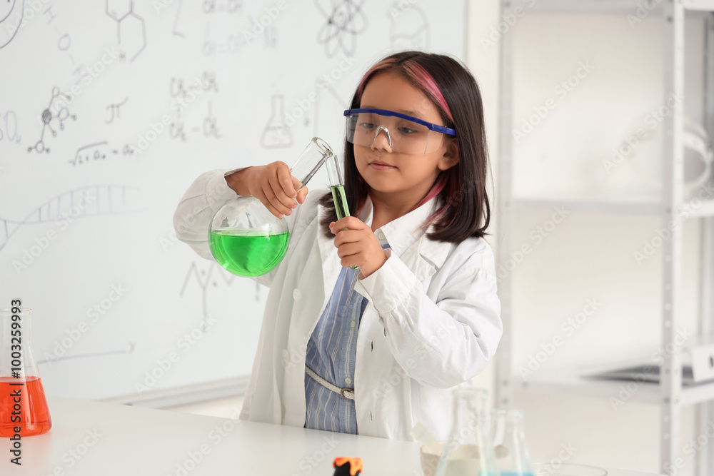 Cute little girl conducting chemistry experiment in science classroom Cute little girl conducting chemistry experiment in science classroom