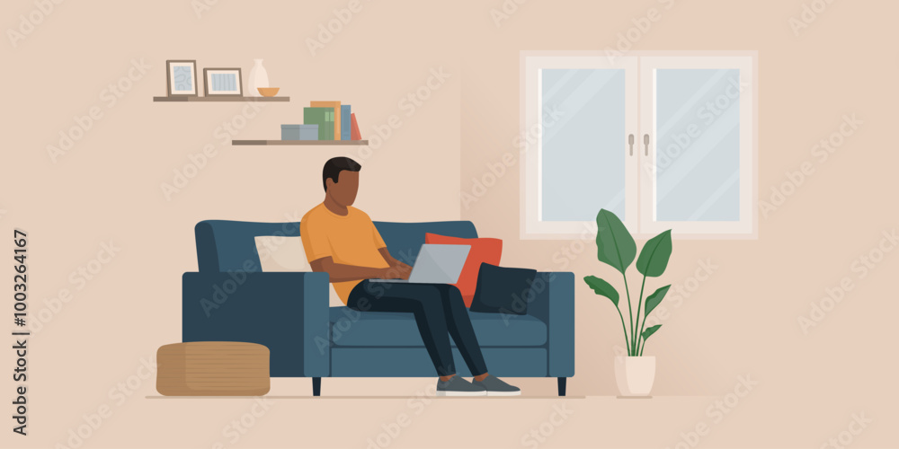 Man sitting on the couch and typing on a laptop