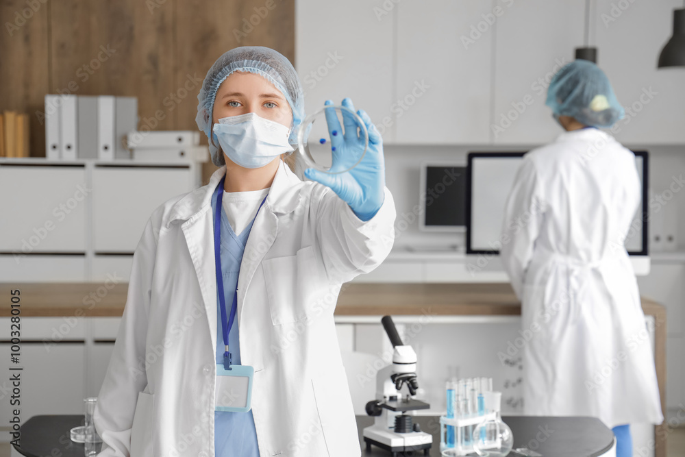 Female scientist with Petri dish in laboratory Female scientist with Petri dish in laboratory