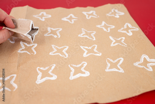 Crafting stars by folding paper rolls into shapes, DIY project for kids, teaching how to create original wrapping paper. Recycled materials, simple activity for fun and creative designs photo