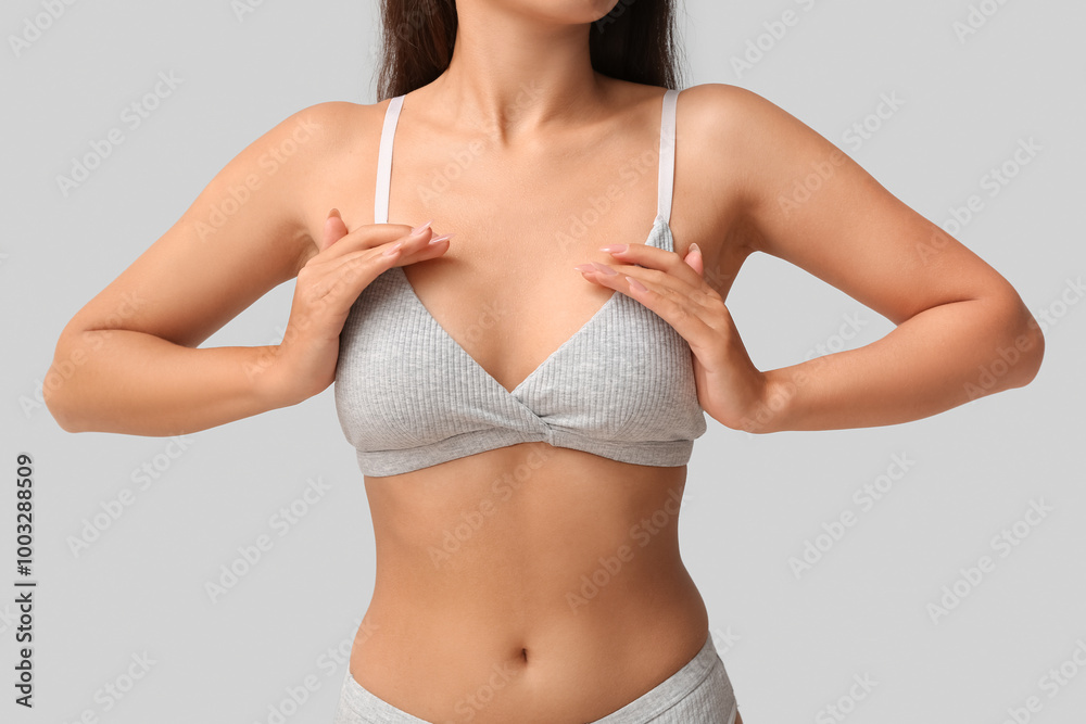 Fototapeta premium Young woman in bra on grey background, closeup