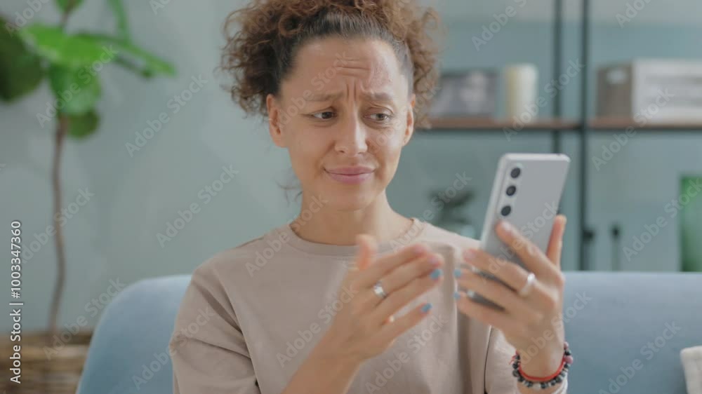 Portrait of Hispanic Woman Criticizing Online Loss Sitting on Sofa at Home Portrait of Hispanic Woman Criticizing Online Loss Sitting on Sofa at Home