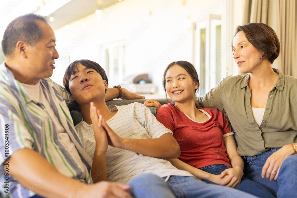 Smiling family sitting on couch, enjoying quality time together Smiling family sitting on couch, enjoying quality time together