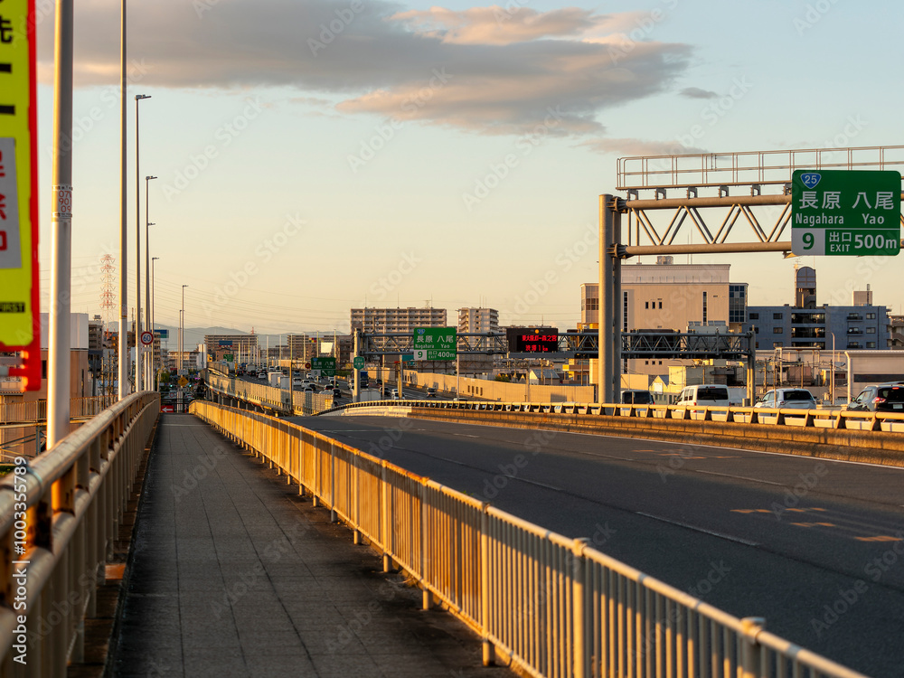 Fototapeta premium 夕日に照らされた街と道路の風景