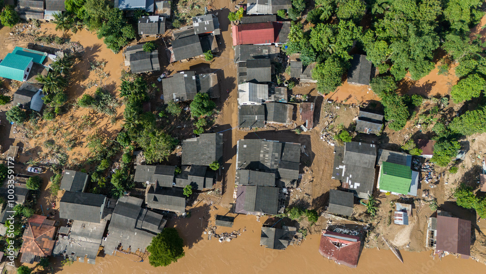 Fototapeta premium Aerial view of Karen Ruammit Elephant Camp village in Chiang Rai province of Thailand flooded by river after typhoon Yagi swept across Thailand.