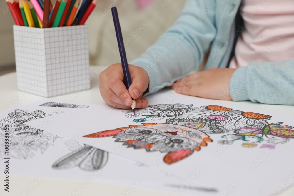 Little girl coloring antistress page at table, closeup Little girl coloring antistress page at table, closeup