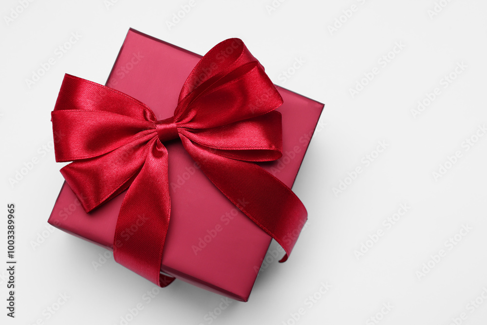 Gift box with bow on light grey background, top view. Space for text Gift box with bow on light grey background, top view. Space for text