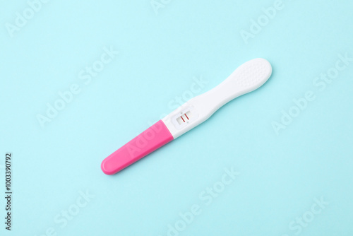 One pregnancy test on light blue background, above view