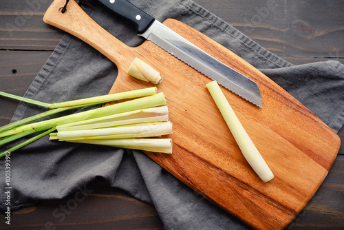 Trimming and Peeling a Lemongrass Stalk: Trimmed and peeled lemongrass stalk on a wooden cutting board with a serrated knife