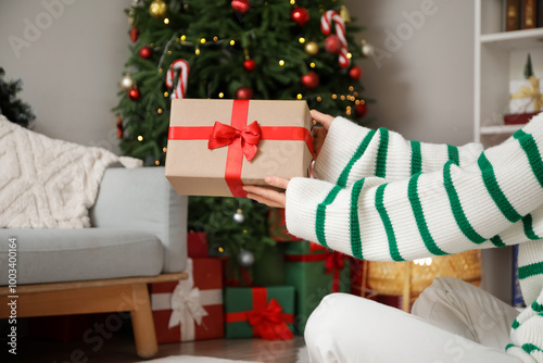Woman giving gift box near ...