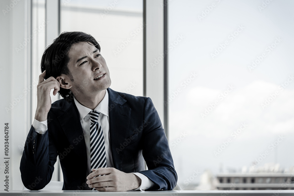 オフィスで悩むアジア人ビジネスマン（転職・起業・悩み・困る）
