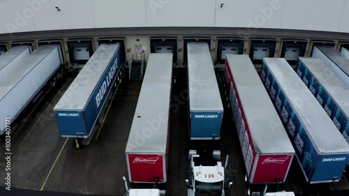 A moody view of a truck yard on a gloomy day, showcasing parked trucks and trailers under overcast skies, capturing the industrial atmosphere and the quietude of the scene.