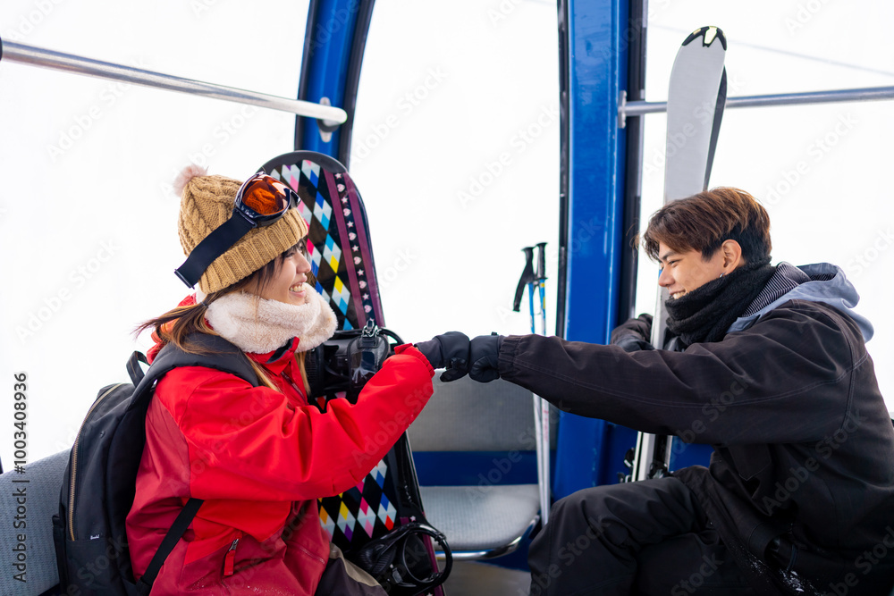 Fototapeta premium Asian man and woman rises to snowy mountain peak on cable car cabin practicing snowboard and ski at ski resort. People enjoy outdoor active lifestyle winter extreme sport training on holiday vacation.