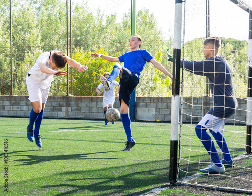 Young football players fighting for ball in goalmouth zone photo