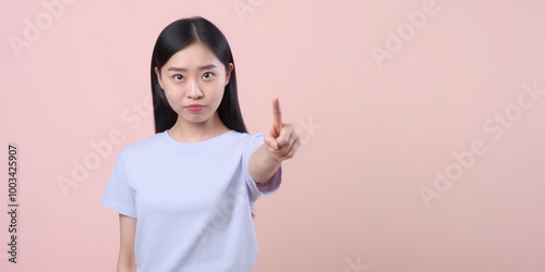 Young Woman Pointing with Serious Expression