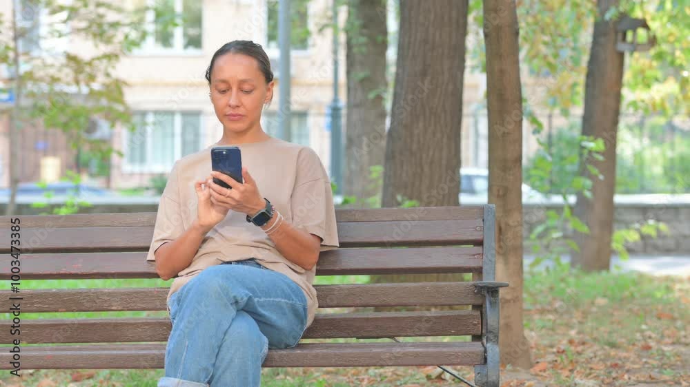 Young Woman Using Smartphone while Sitting Outdoor Young Woman Using Smartphone while Sitting Outdoor