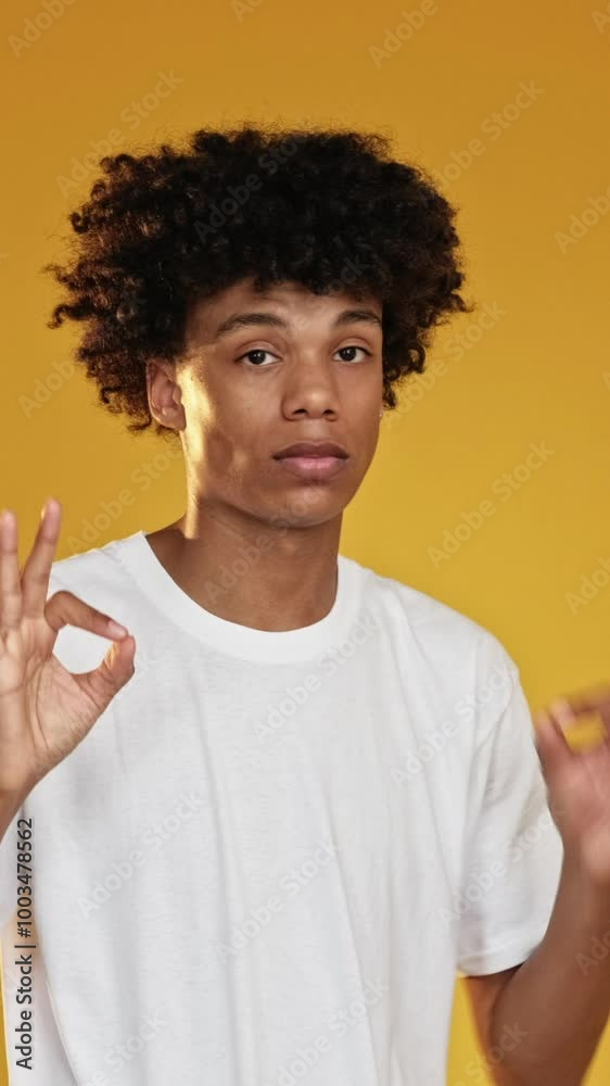 Vertical video. Okay gesture. Positive approval. Affirmative body language. Friendly encouragement. Impressed guy supporting with thumbs up like isolated on yellow background. Vertical video. Okay gesture. Positive approval. Affirmative body language. Friendly encouragement. Impressed guy supporting with thumbs up like isolated on yellow background.