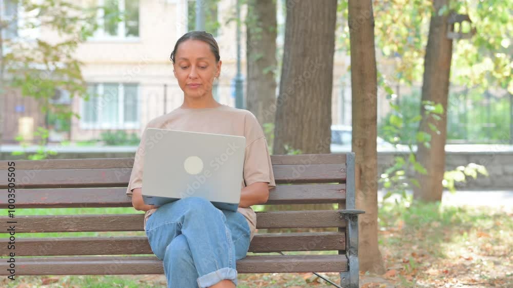 Shocked Young Woman Using Laptop Looking at Camera Outdoor on Bench Shocked Young Woman Using Laptop Looking at Camera Outdoor on Bench