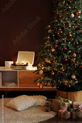 Cozy modern living room with wooden furniture decorated for Christmas with a tree with gold and brown ornaments. Gifts in craft packaging under the tree.