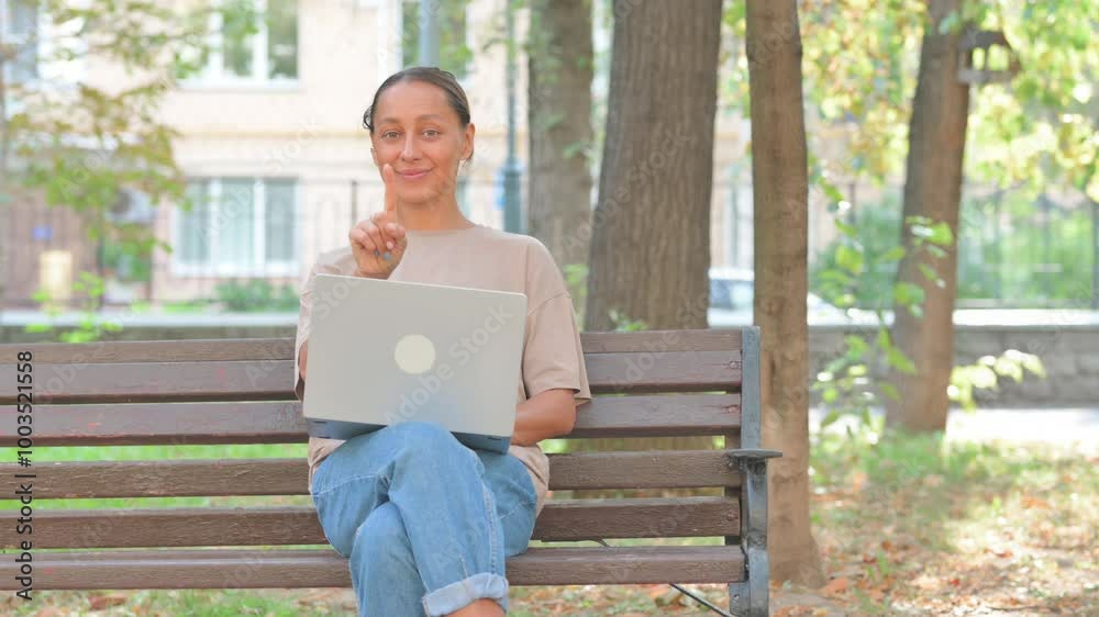 Rejecting Young Woman in Denial Using Laptop Outdoor on Bench Rejecting Young Woman in Denial Using Laptop Outdoor on Bench
