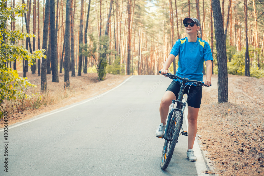 Fototapeta premium woman cyclist rides in the forest on a bike.