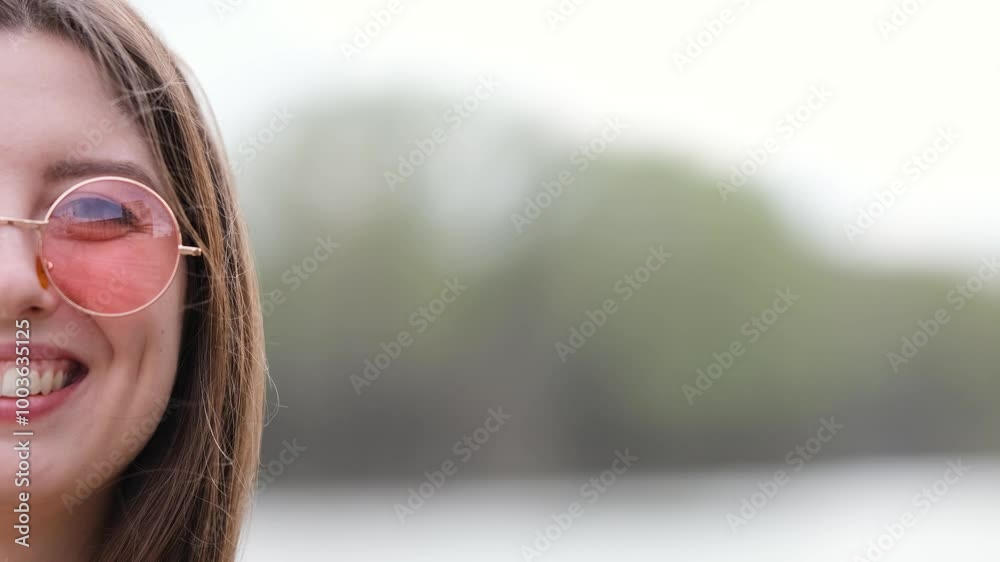 Happy woman in pink sunglasses outdoors smiling Happy woman in pink sunglasses outdoors smiling