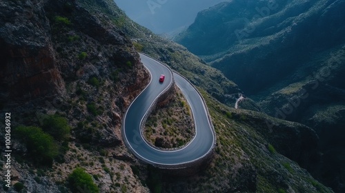 A scenic view of a winding road through mountainous terrain, surrounded by lush greenery and steep cliffs. photo