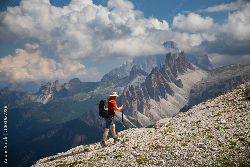 Fototapeta premium Man traveler traveling alone in breathtaking landscape of Dolomites Mounatains. Travel lifestyle wanderlust adventure concept.