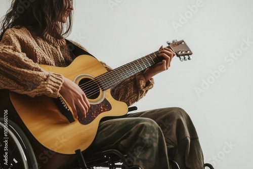 Person in wheelchair playing acoustic guitar, serene atmosphere. photo