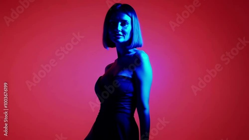 Woman in dramatic blue and red lighting with short hair in a strapless dress