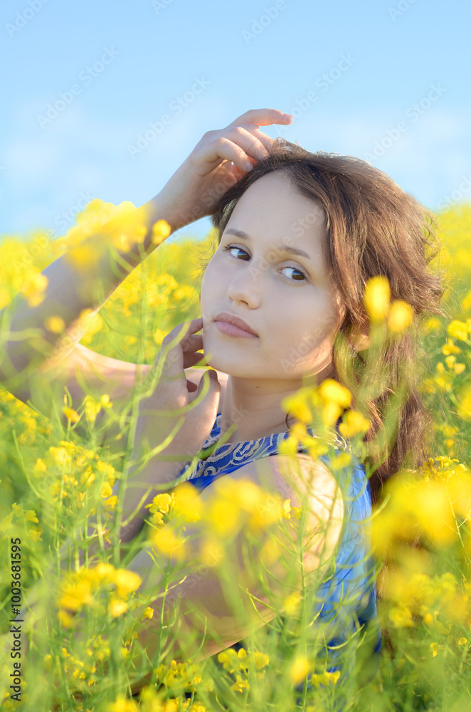 girl in a blue dress in a rapeseed field girl in a blue dress in a rapeseed field