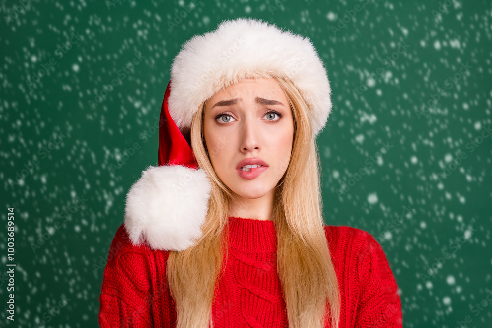 Photo portrait blonde woman in santa hat stressed biting lip isolated green color background Photo portrait blonde woman in santa hat stressed biting lip isolated green color background